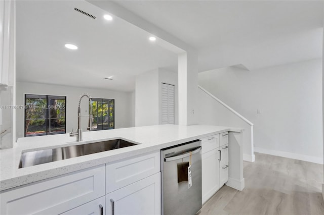 kitchen featuring light hardwood / wood-style flooring, dishwasher, light stone countertops, white cabinets, and sink