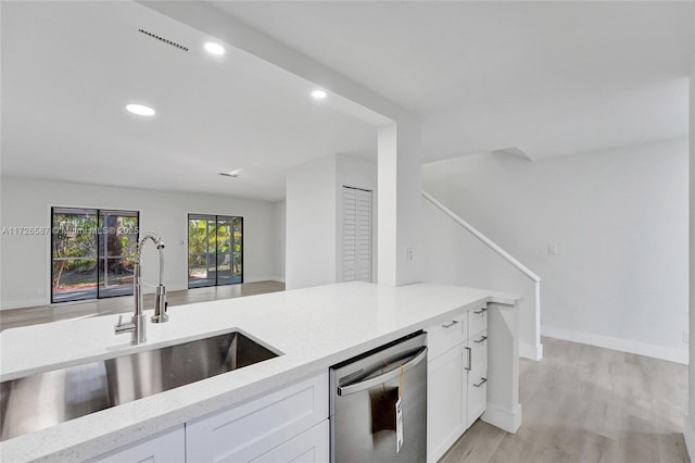 kitchen featuring white cabinetry, light hardwood / wood-style flooring, sink, and dishwasher