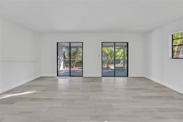 spare room featuring light wood-type flooring and a wealth of natural light