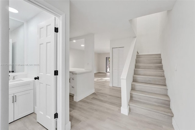 staircase with sink and wood-type flooring