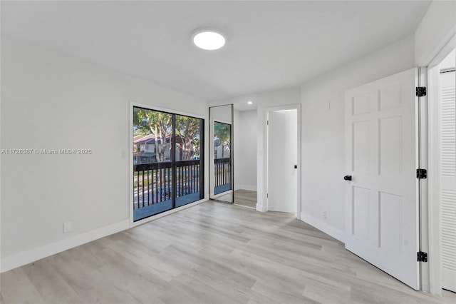 spare room with light wood-type flooring and access to exterior