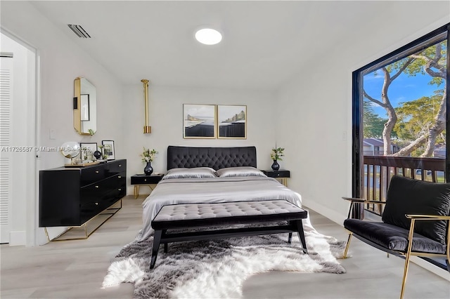 bedroom with light wood-type flooring and access to exterior