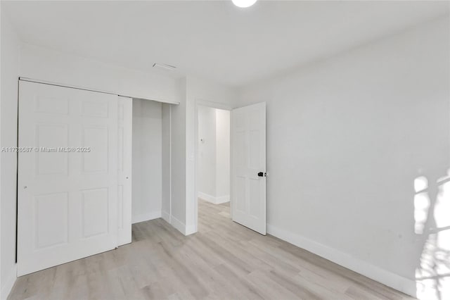 unfurnished bedroom featuring light hardwood / wood-style floors and a closet