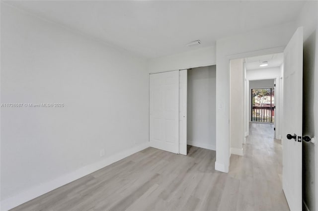 unfurnished bedroom featuring light hardwood / wood-style flooring and a closet