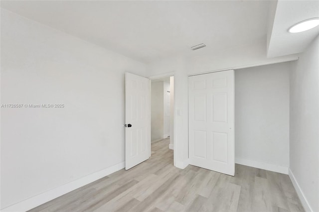 unfurnished bedroom featuring a closet and light hardwood / wood-style flooring