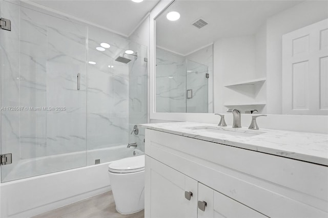 full bathroom with toilet, vanity, and bath / shower combo with glass door