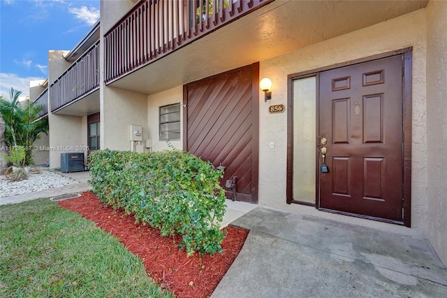 doorway to property with central air condition unit and a balcony