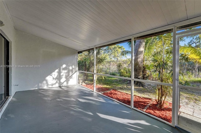 unfurnished sunroom featuring lofted ceiling and a healthy amount of sunlight