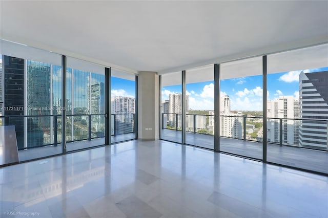 empty room with expansive windows, a healthy amount of sunlight, and tile patterned flooring