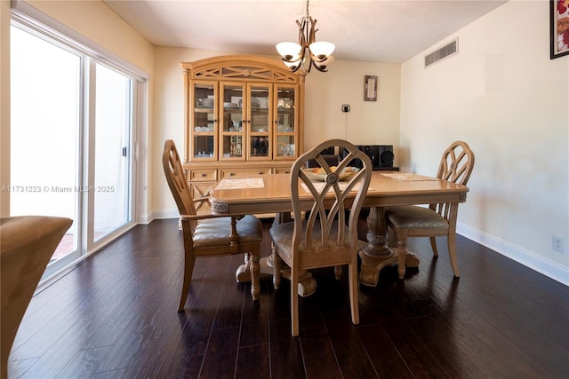 dining area with a chandelier and dark hardwood / wood-style flooring