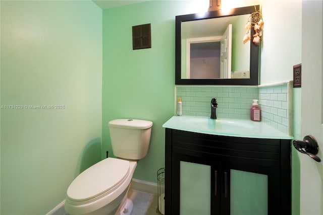 bathroom with vanity, toilet, and backsplash