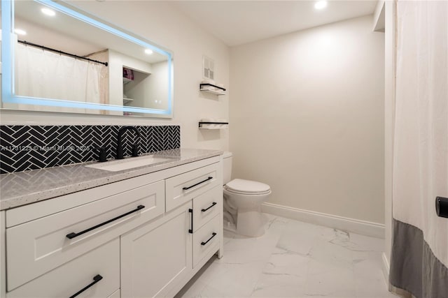 bathroom with tasteful backsplash, vanity, and toilet