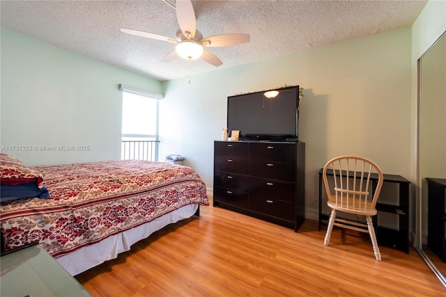 bedroom featuring a textured ceiling, light hardwood / wood-style flooring, a closet, and ceiling fan