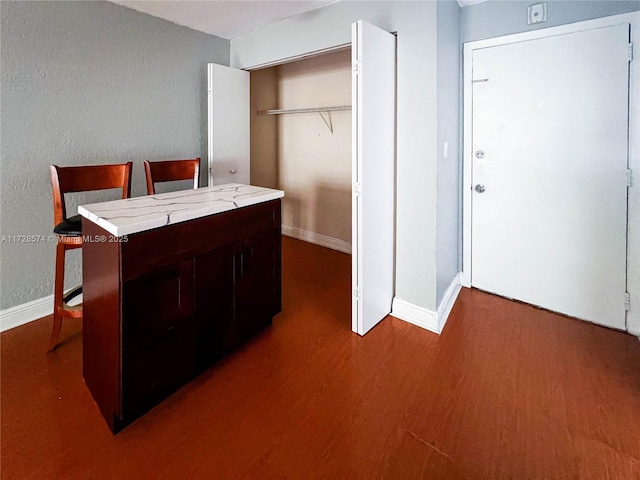 kitchen featuring dark hardwood / wood-style flooring and dark brown cabinets