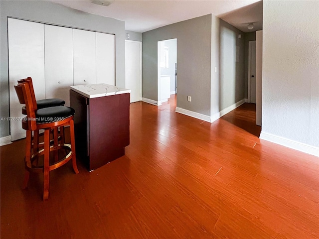 interior space with hardwood / wood-style floors and a kitchen bar