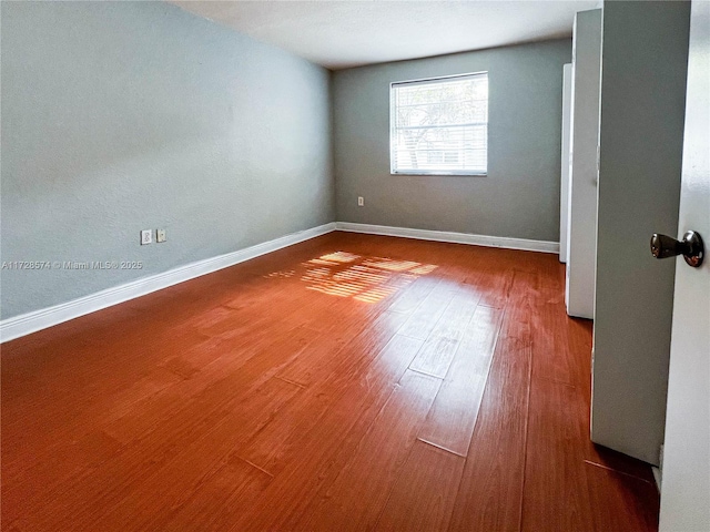 spare room featuring wood-type flooring