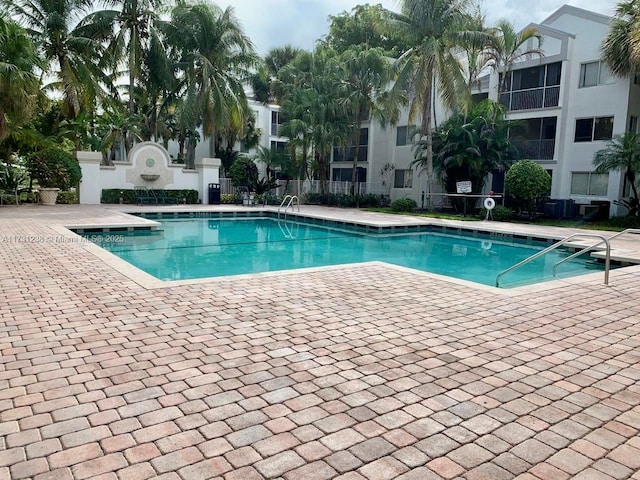 view of swimming pool with cooling unit and a patio