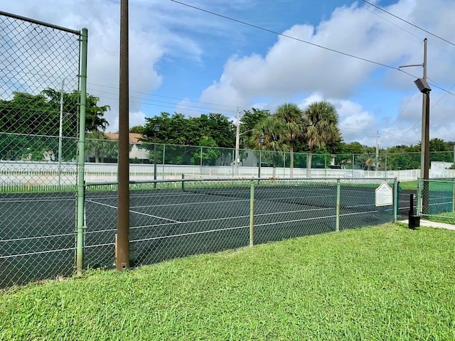 view of tennis court featuring a yard