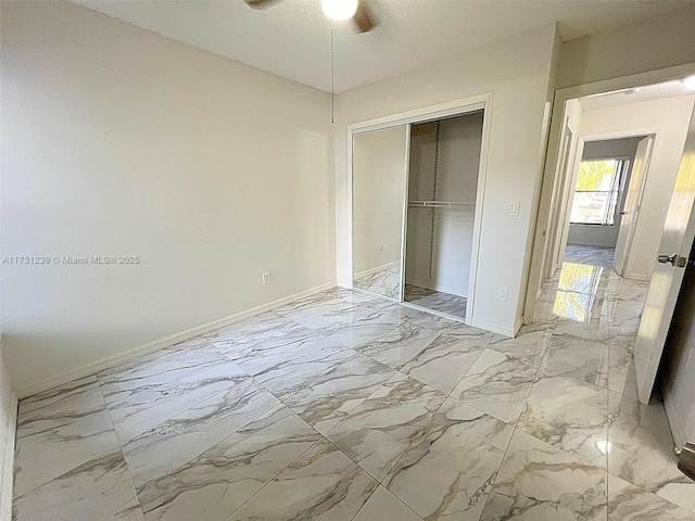 unfurnished bedroom with ceiling fan and a closet