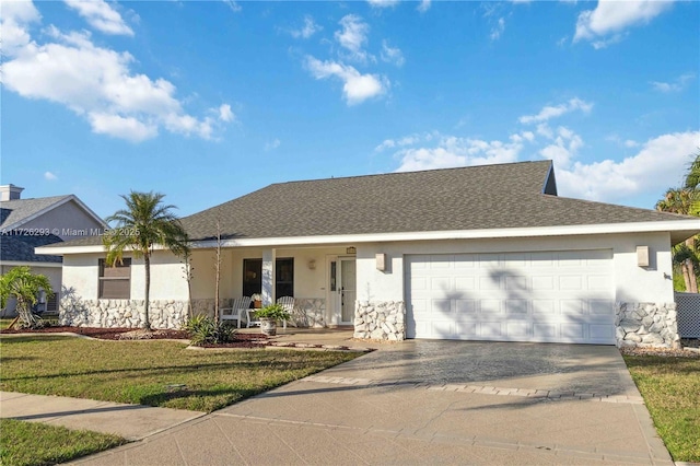 ranch-style house featuring a porch, a garage, and a front yard