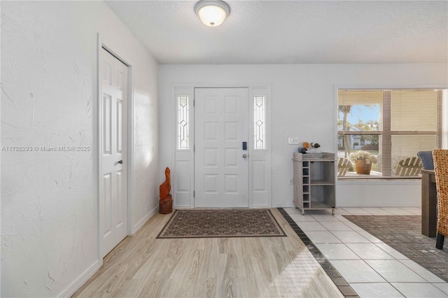 entrance foyer with a textured ceiling and light hardwood / wood-style floors