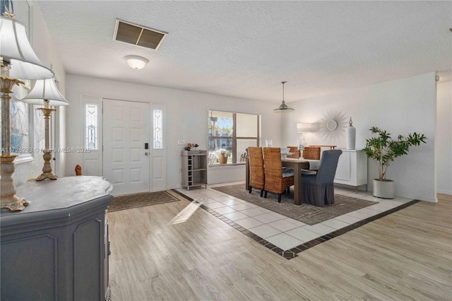 foyer with light hardwood / wood-style floors and a textured ceiling