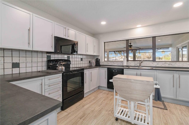 kitchen featuring white cabinets, sink, and black appliances