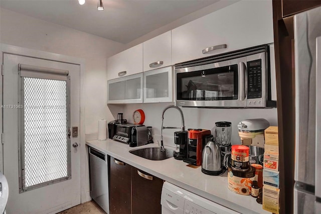 kitchen featuring appliances with stainless steel finishes, sink, and white cabinets