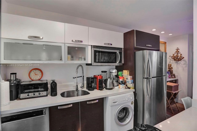 kitchen featuring dark brown cabinetry, sink, appliances with stainless steel finishes, washer / clothes dryer, and white cabinets