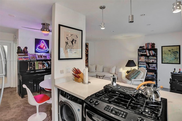 kitchen with decorative light fixtures, gas stove, and independent washer and dryer