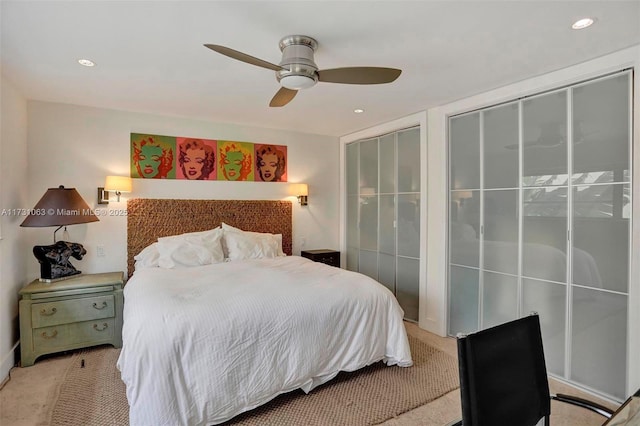 carpeted bedroom featuring ceiling fan and two closets