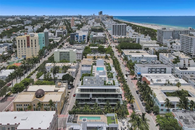 birds eye view of property with a water view and a beach view