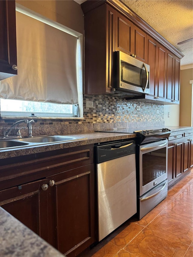 6150 NW 62nd St Unit 312, Tamarac, FL 33319 - kitchen with a sink, appliances with stainless steel finishes, a textured ceiling, dark countertops, and decorative backsplash