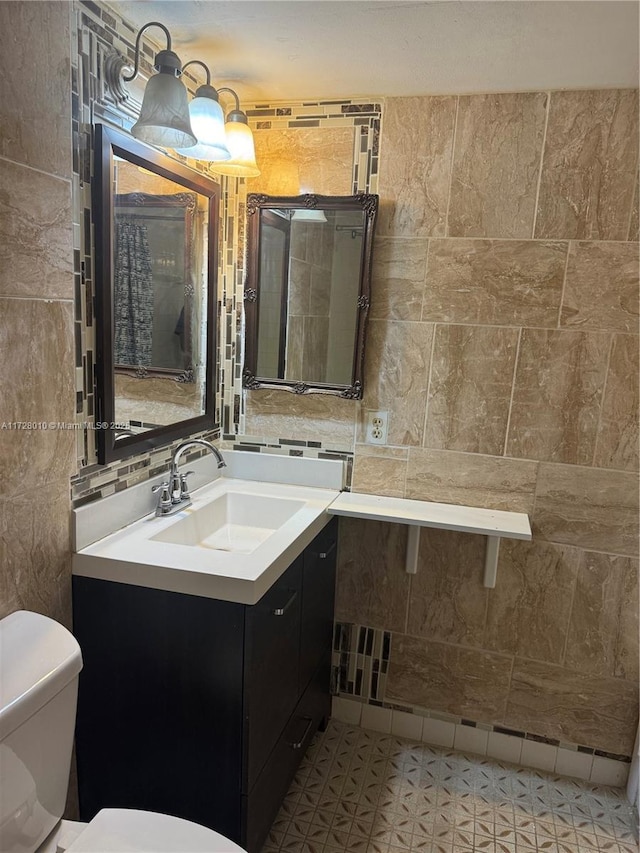 bathroom featuring decorative backsplash, vanity, toilet, and tile walls