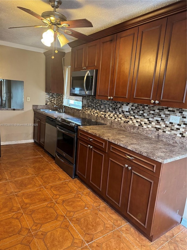 kitchen with decorative backsplash, stainless steel appliances, sink, and a textured ceiling