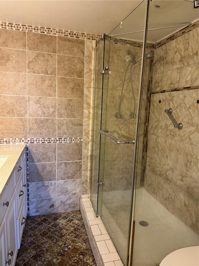 bathroom with tiled shower, vanity, and toilet