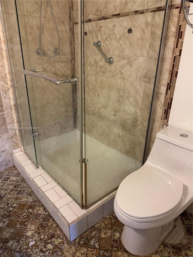 bathroom with toilet and a shower with shower door