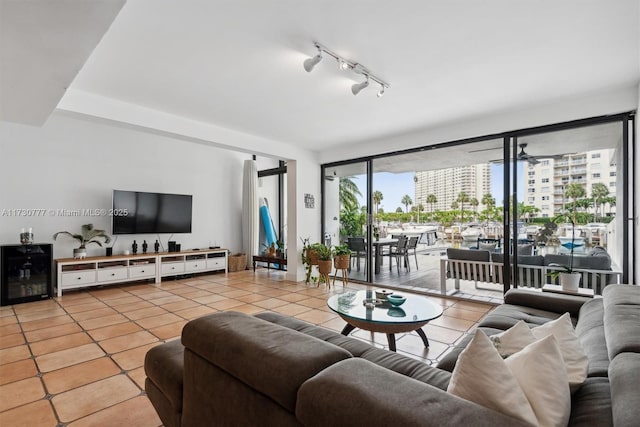 tiled living room featuring rail lighting and ceiling fan