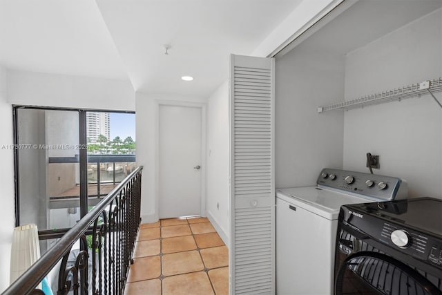 laundry room with light tile patterned floors and washer and clothes dryer