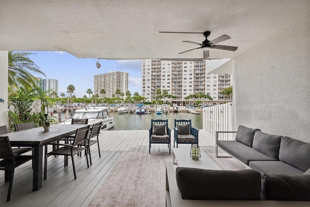 deck with a water view, ceiling fan, and outdoor lounge area