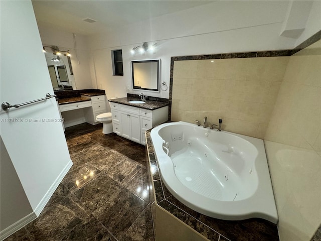 bathroom featuring vanity, a relaxing tiled tub, and toilet