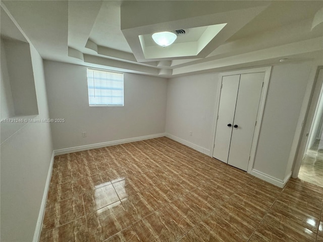 interior space featuring a tray ceiling and a closet