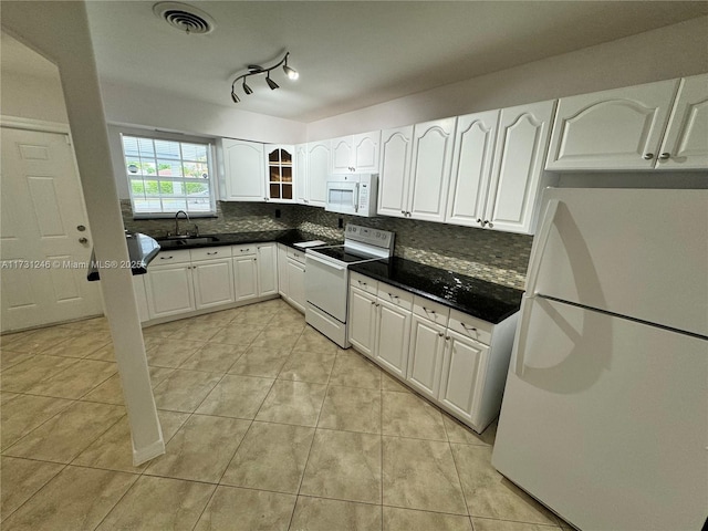 kitchen featuring white cabinetry, sink, backsplash, light tile patterned floors, and white appliances