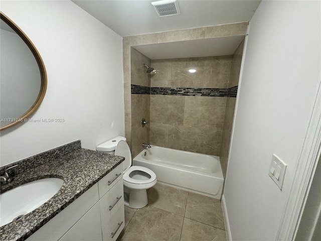 full bathroom featuring vanity, tile patterned flooring, tiled shower / bath combo, and toilet