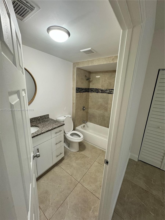 full bathroom featuring tiled shower / bath, vanity, and toilet