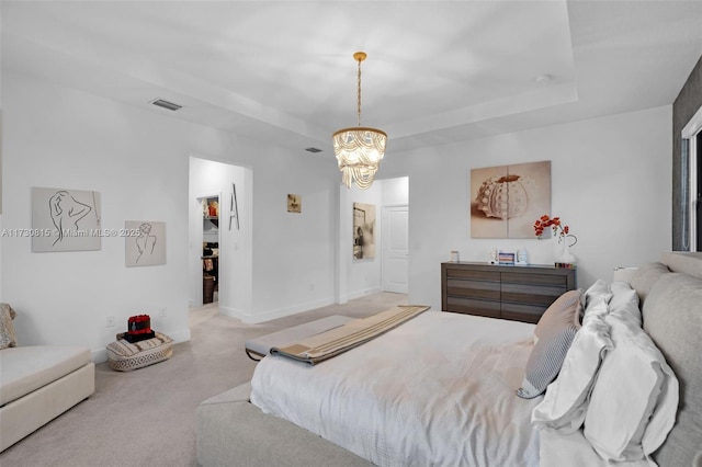 bedroom featuring light carpet, a raised ceiling, and an inviting chandelier