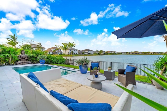 view of pool featuring outdoor lounge area, a patio, and a water view