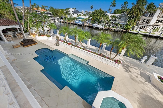 view of swimming pool featuring exterior bar, an in ground hot tub, a patio, and a water view