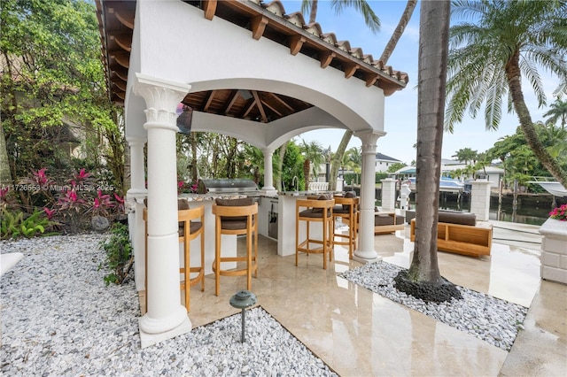 view of patio / terrace with a gazebo, area for grilling, a grill, and exterior bar