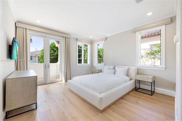 bedroom featuring french doors, ornamental molding, light hardwood / wood-style flooring, and access to outside